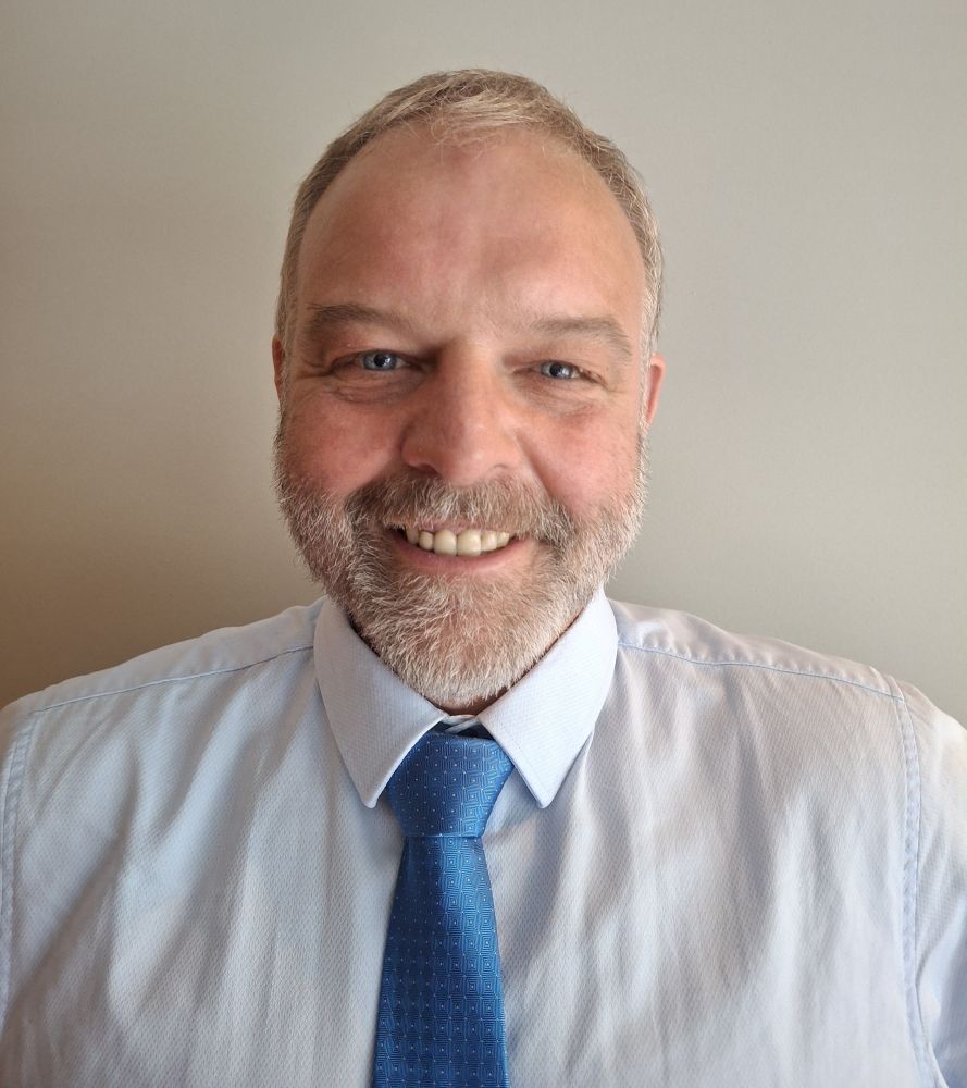 A man, Prys Morgan, in a shirt and tie smiling.